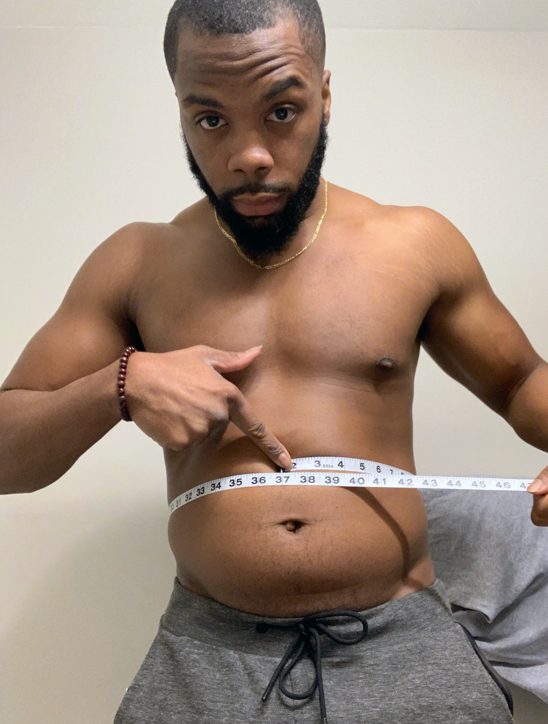 Najee Kelley using body tape measurer for fat loss